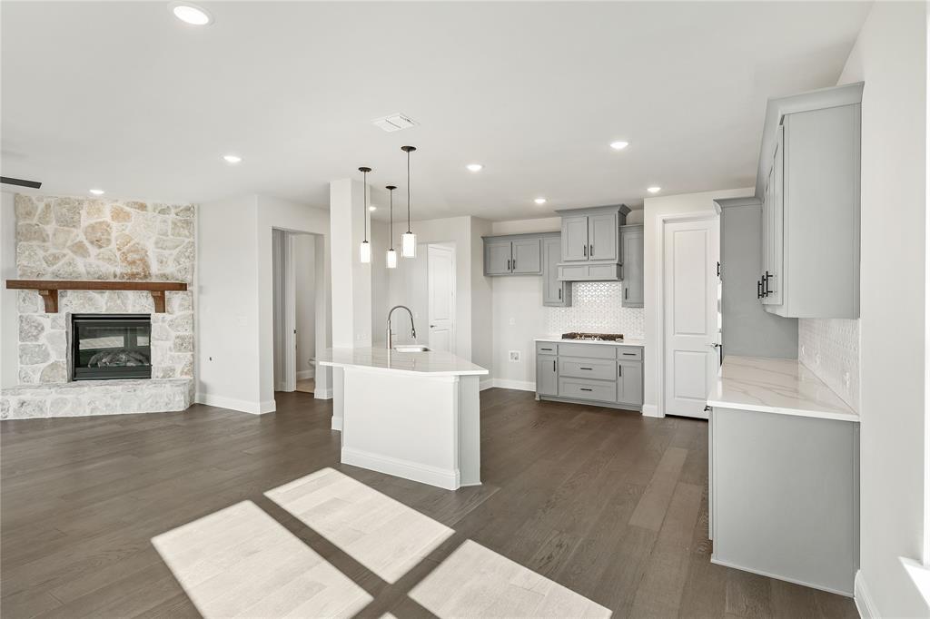 8 Grouse Circle Sanger, TX 76266 - Photo 14 of 40 a open kitchen with white cabinets and a fireplace