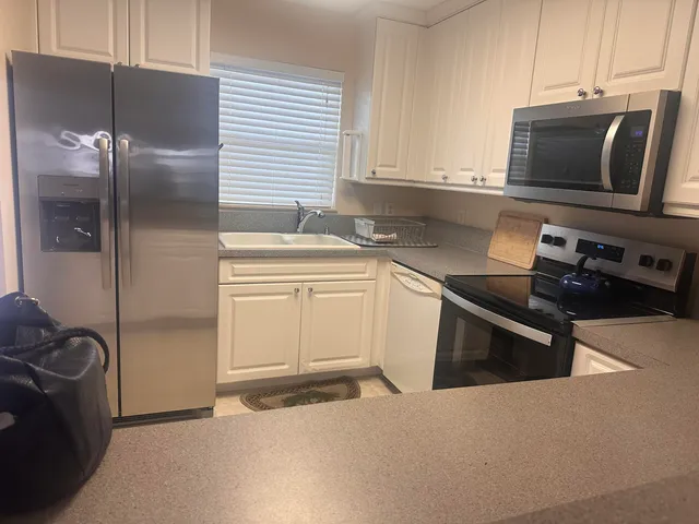 a kitchen with stainless steel appliances a stove microwave and refrigerator