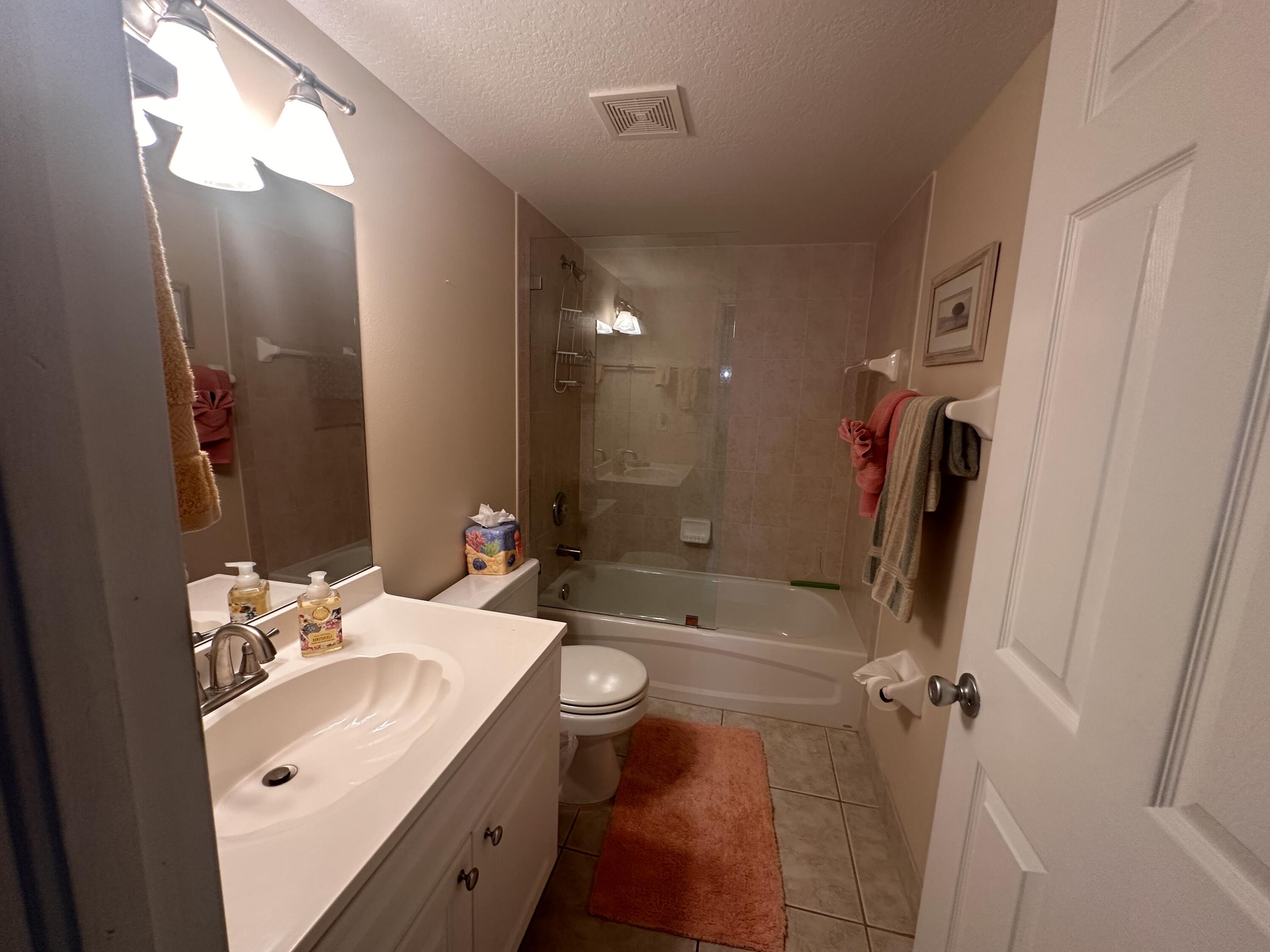 2950 Southeast Ocean Boulevard, Unit 182 Stuart, FL 34996 - Photo 11 of 13 a bathroom with a sink a toilet and shower