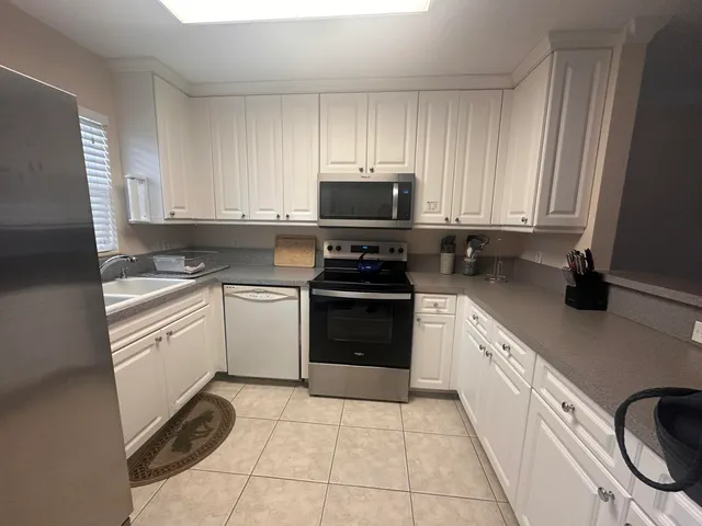 a kitchen with cabinets stainless steel appliances and a sink