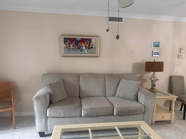 a living room with furniture a couch and a lamp on a bookshelf