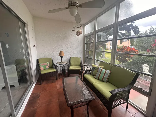 a living room with furniture and a floor to ceiling window