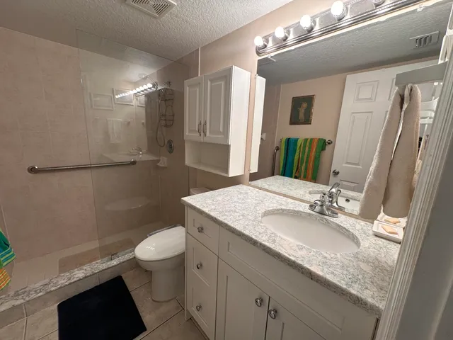 a bathroom with a granite countertop sink toilet and shower
