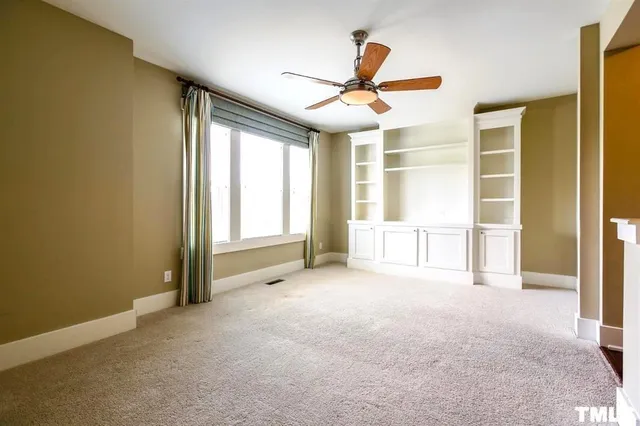 a view of a livingroom with a ceiling fan and window