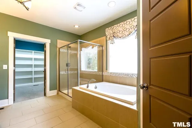a spacious bathroom with a bathtub and a shower