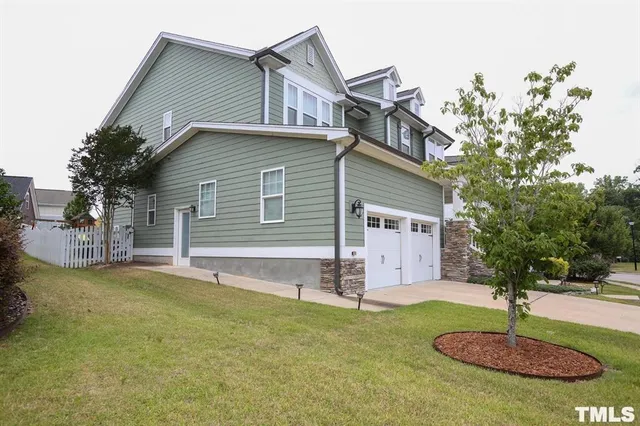 a front view of house with yard and trees in the background