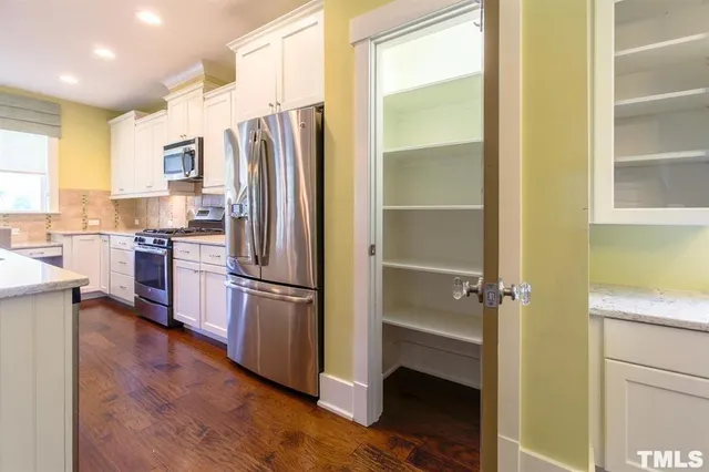 a kitchen with a refrigerator a sink and cabinets
