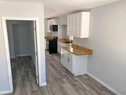 a kitchen with sink cabinets and wooden floor