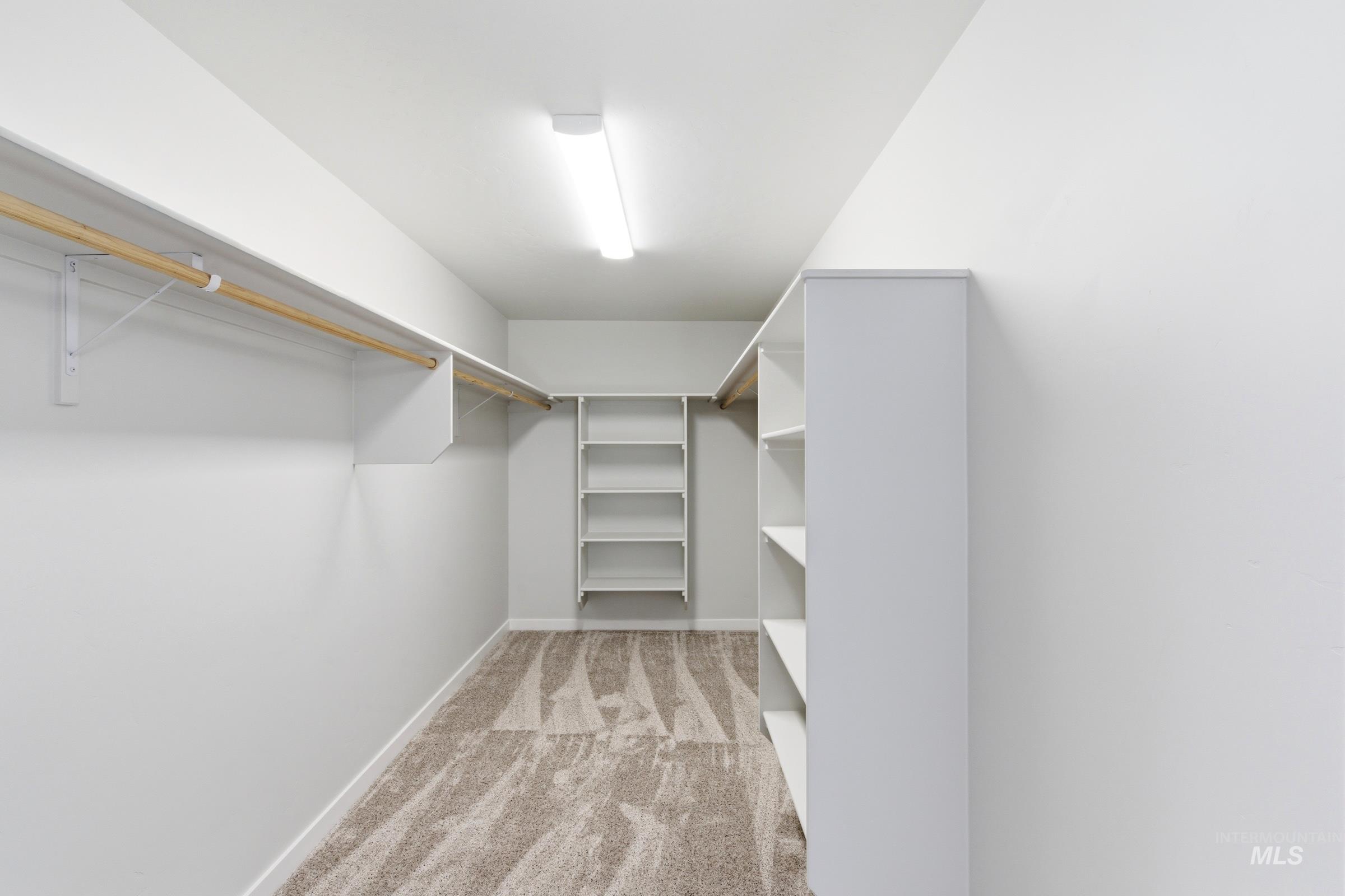 13677 Redway Court Caldwell, ID 83607 - Photo 35 of 35 Spacious walk-in closet featuring extensive built-in shelving, hanging rods, and neutral-toned carpeting