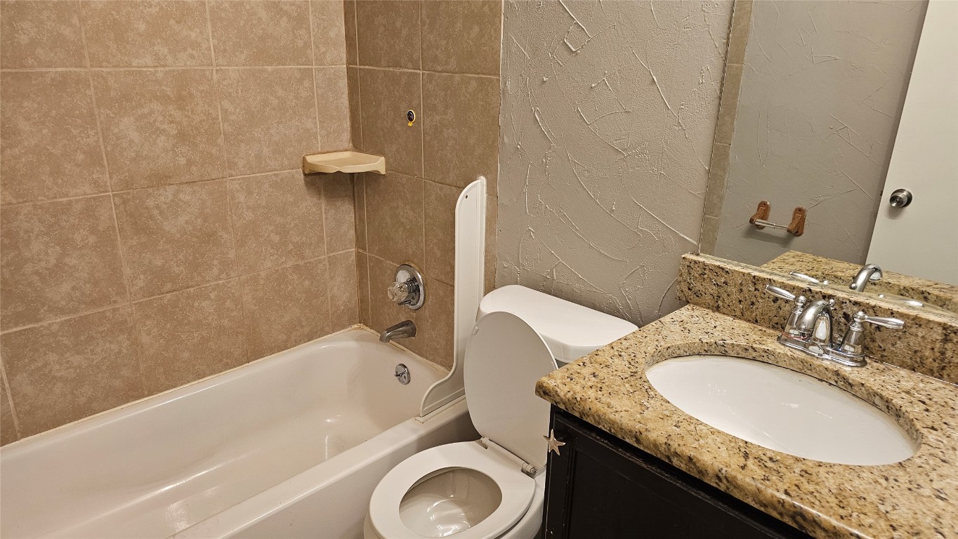 1903 1/2 Margalene Way, Unit B Austin, TX 78728 - Photo 11 of 17 Bathroom featuring toilet, shower / washtub combination, vanity, and a textured wall
