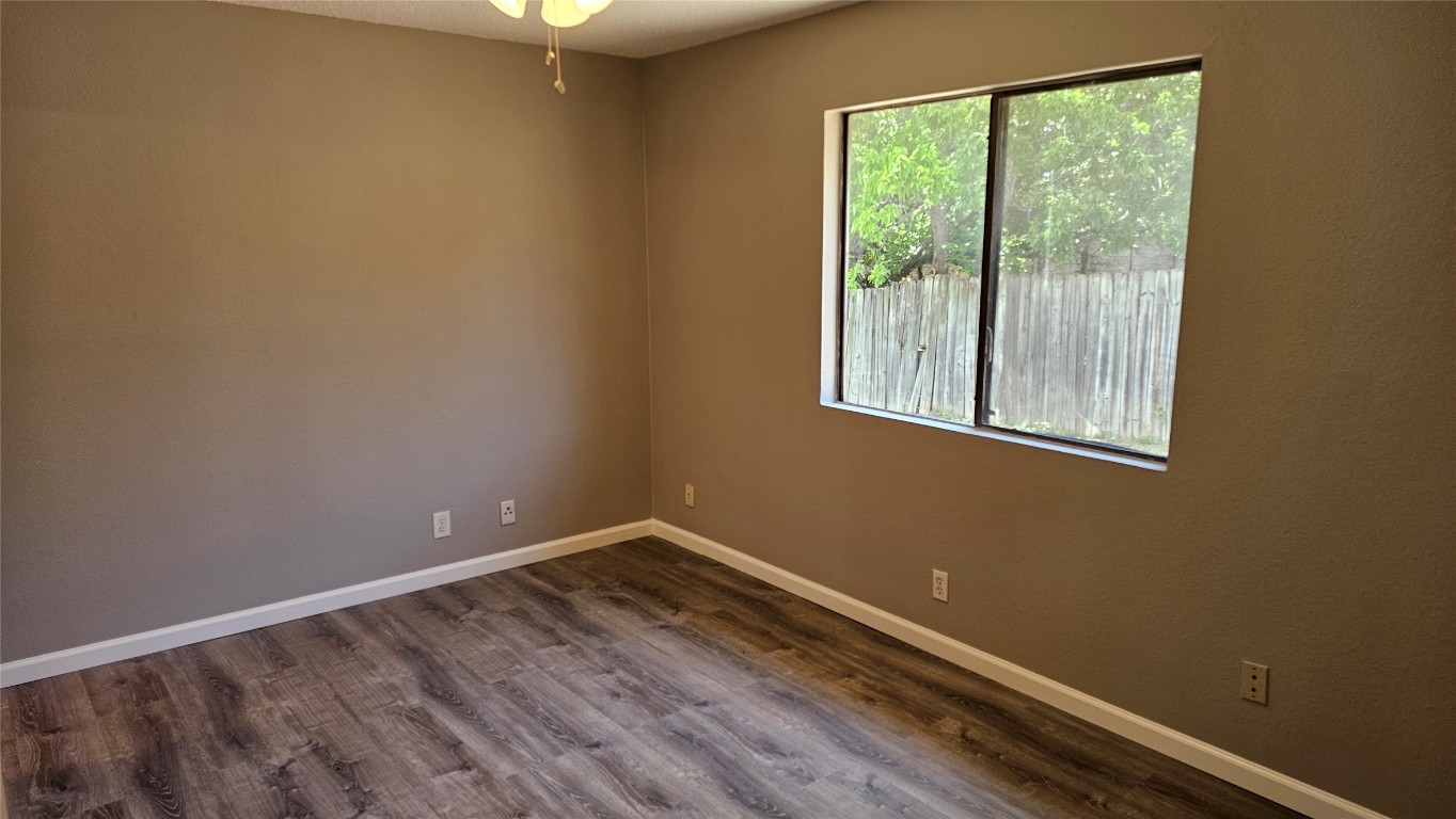 1903 1/2 Margalene Way, Unit B Austin, TX 78728 - Photo 12 of 17 Empty room with baseboards, dark wood-style floors, and ceiling fan