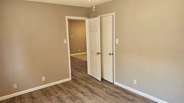 an empty room with wooden floor and mirror