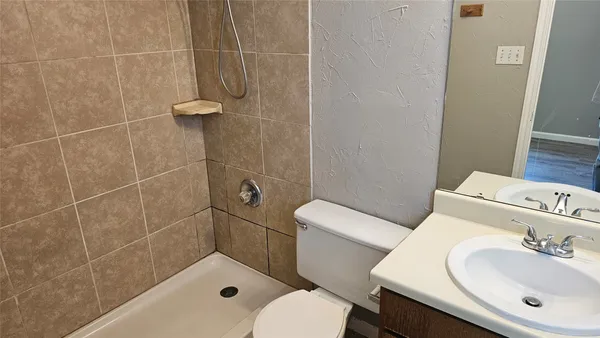 a bathroom with a sink a toilet and shower