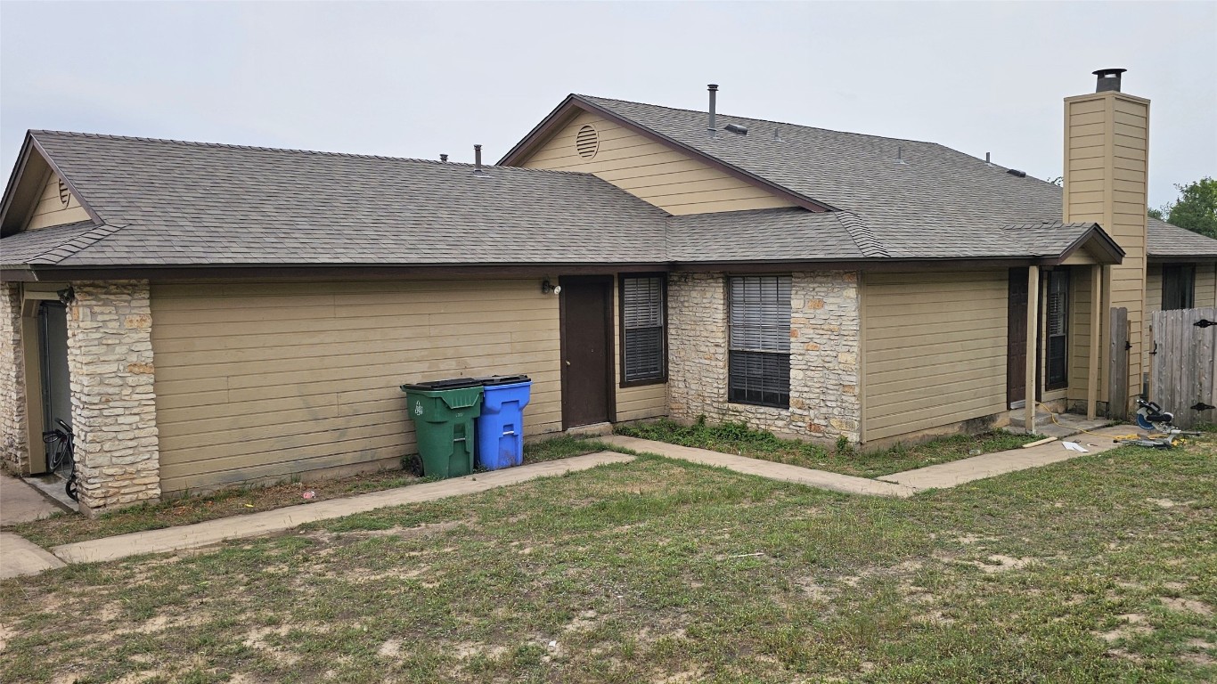 1903 1/2 Margalene Way, Unit B Austin, TX 78728 - Photo 17 of 17 Back of property featuring stone siding, a chimney, and a shingled roof