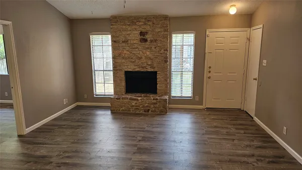 an empty room with windows and a fireplace