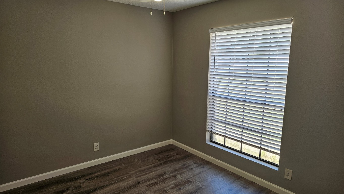 1903 1/2 Margalene Way, Unit B Austin, TX 78728 - Photo 8 of 17 Empty room with dark wood-style floors, baseboards, and ceiling fan