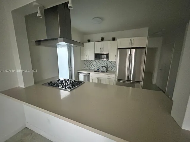 a kitchen with stainless steel appliances a refrigerator and a stove