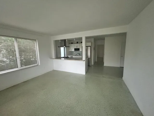 an empty room with a fireplace and large window