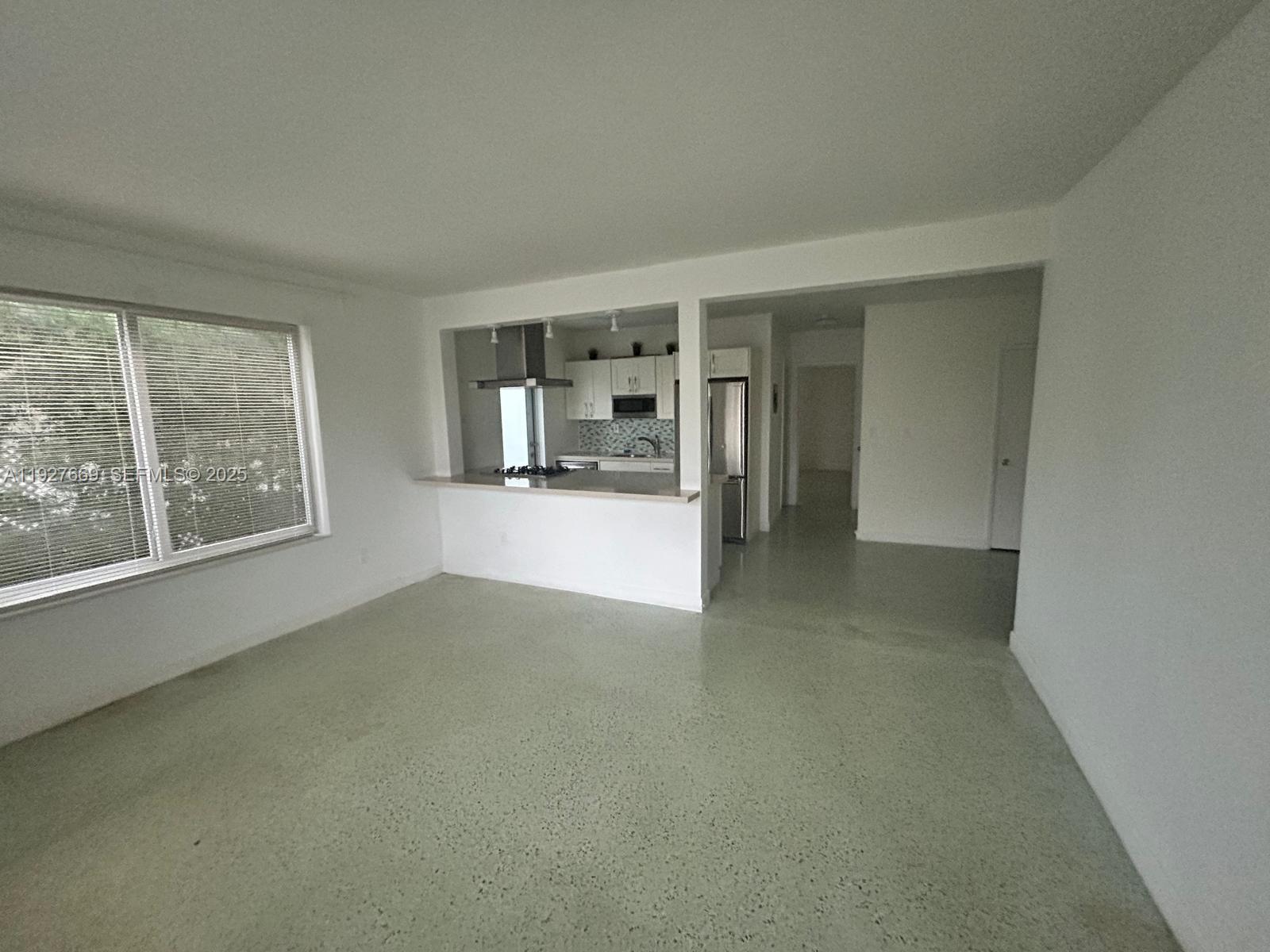 7430 Carlyle Avenue, Unit 1 Miami Beach, FL 33141 - Photo 3 of 6 an empty room with a fireplace and large window