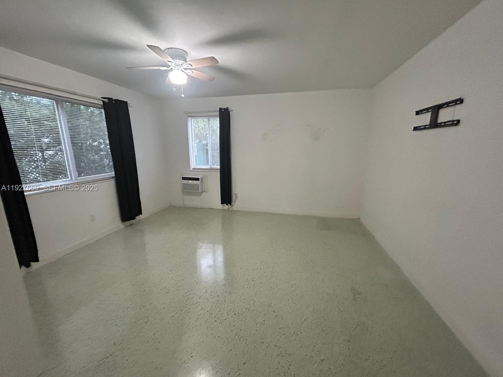 7430 Carlyle Avenue, Unit 1 Miami Beach, FL 33141 - Photo 5 of 6 wooden floor in an empty room with a window