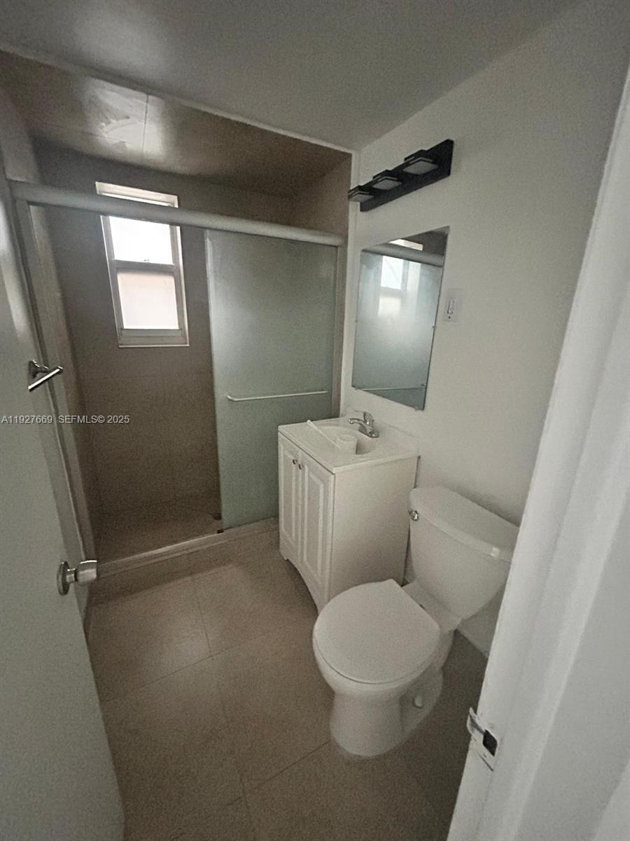 7430 Carlyle Avenue, Unit 1 Miami Beach, FL 33141 - Photo 6 of 6 a white toilet sitting next to a bathroom sink