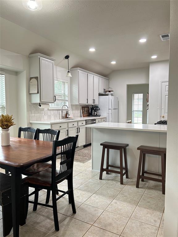 a kitchen with stainless steel appliances granite countertop a stove a sink a table and chairs