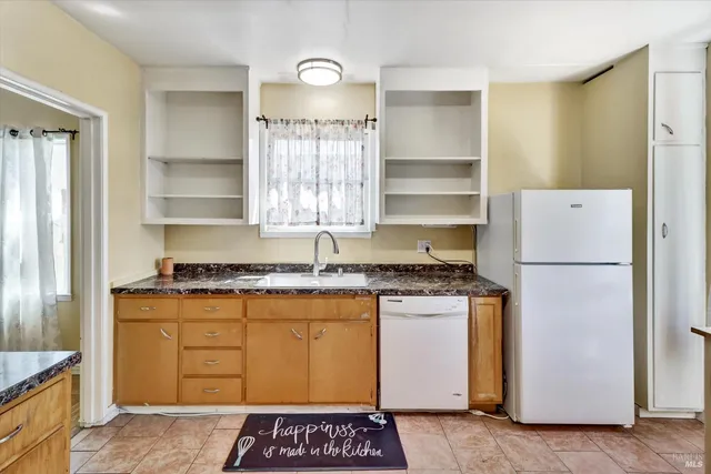 a kitchen with granite countertop a sink and a stove