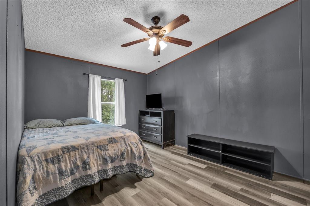 3615 Spring Valley Road Lorena, TX 76655 - Photo 11 of 33 Spacious room featuring wood-finish flooring, a ceiling fan with integrated lighting, and a window providing natural light