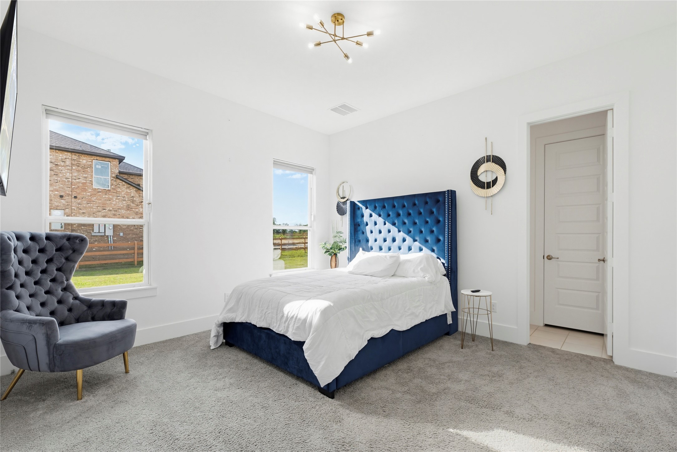 29526 Cir S Rnch Trail Fulshear, TX 77406 - Photo 24 of 47 This bright first-floor secondary bedroom features high-contrast designer finishes. With large windows overlooking the estate, this versatile room is ideal for guests who value privacy and style.