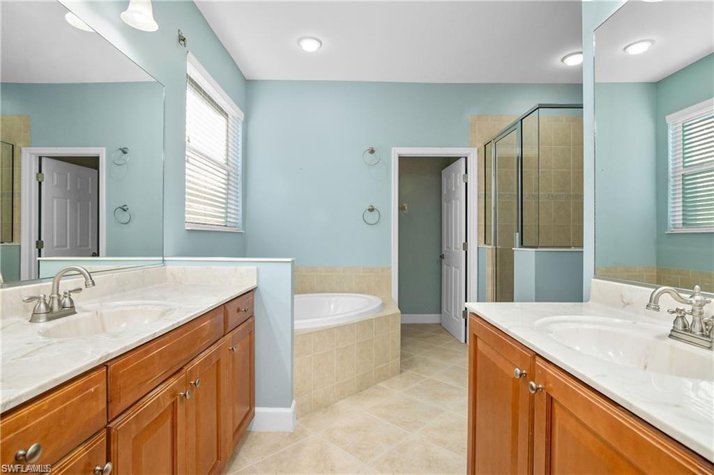 20437 Ardore Lane Estero, FL 33928 - Photo 17 of 36 a spacious bathroom with a granite countertop sink a toilet a mirror and bathtub