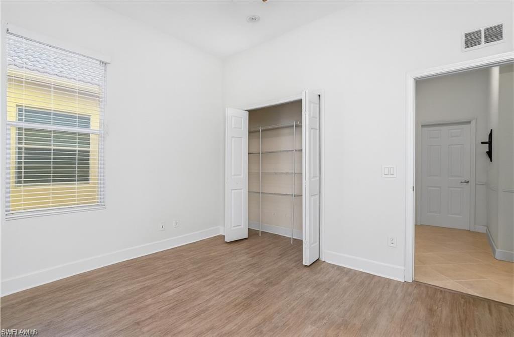 20437 Ardore Lane Estero, FL 33928 - Photo 24 of 36 an empty room with wooden floor and windows