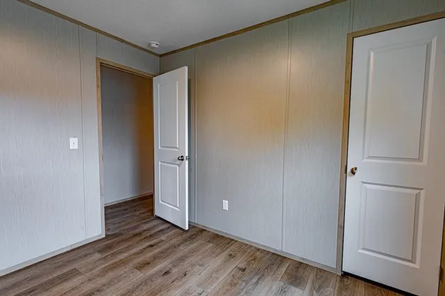 an empty room with wooden floor and closet