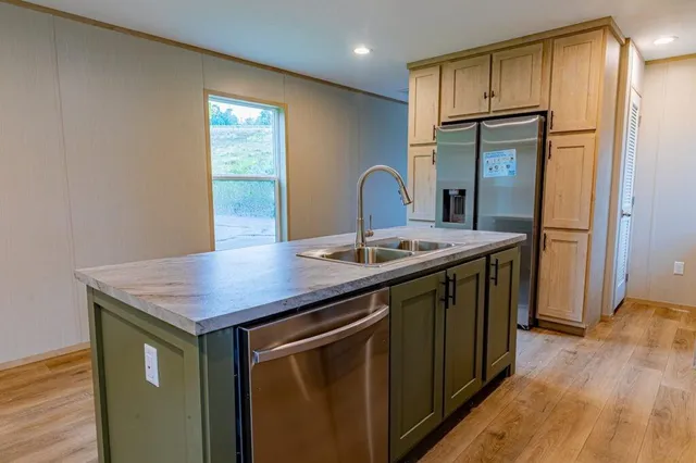 a kitchen with a sink a refrigerator and wooden floor