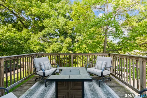 a balcony with wooden floor and outdoor seating