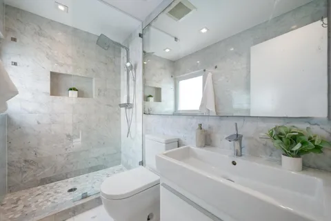 a bathroom with a sink a toilet and shower