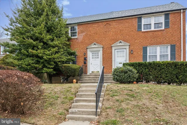 a front view of a house with plants and trees