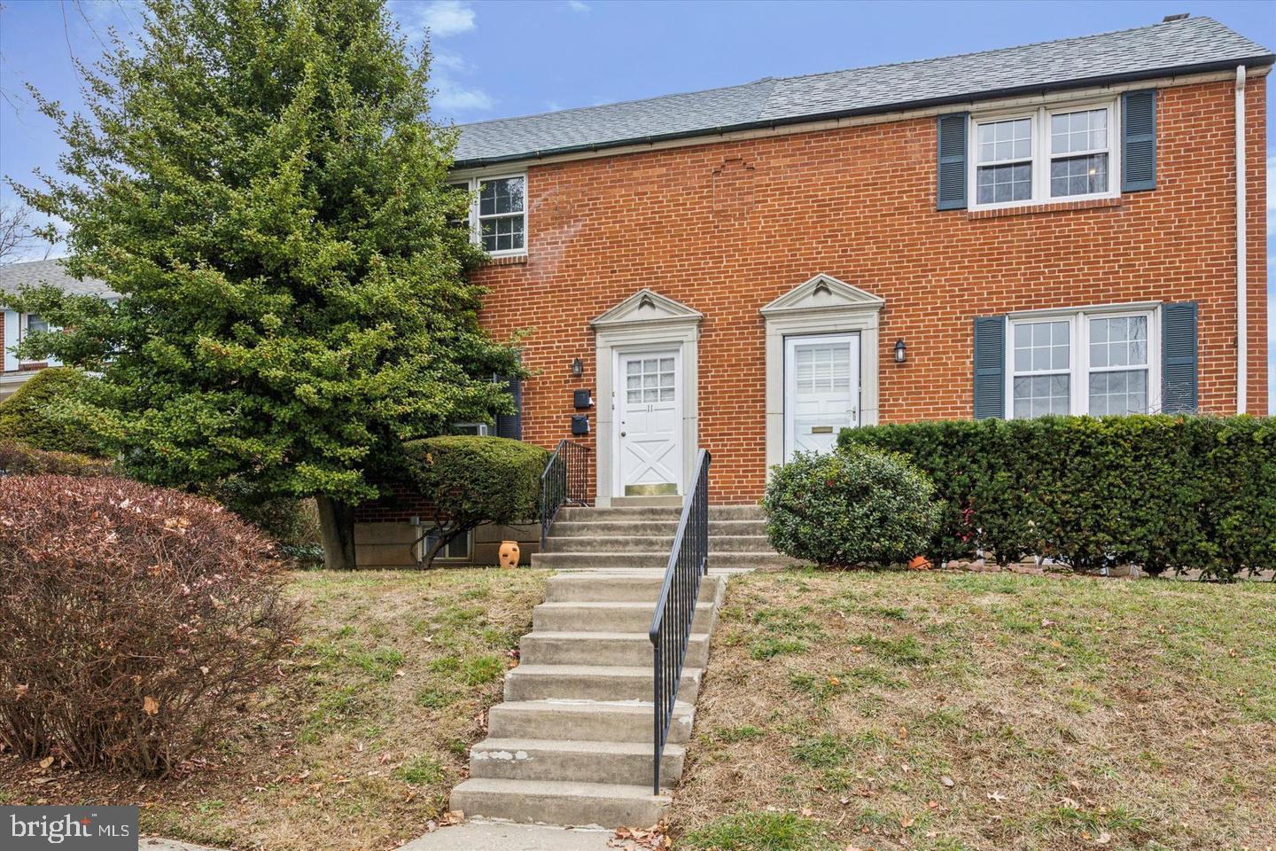 a front view of a house with plants and trees
