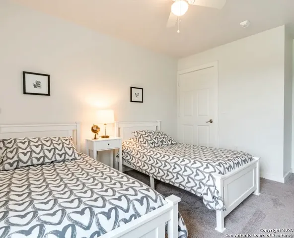 a bedroom with two beds and painting on the wall