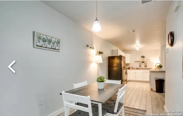 a kitchen with stainless steel appliances wooden floor and a refrigerator