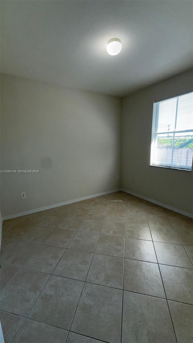 13810 Southwest 276th Street, Unit 13810 Homestead, FL 33032 - Photo 25 of 38 an empty room with a empty space and windows