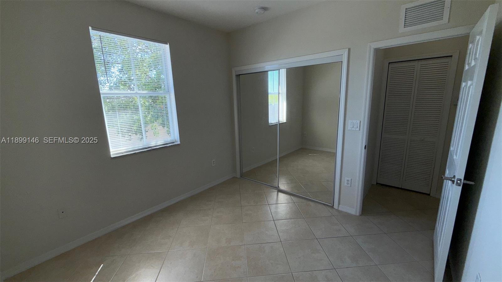 13810 Southwest 276th Street, Unit 13810 Homestead, FL 33032 - Photo 29 of 38 an empty room with windows and closet