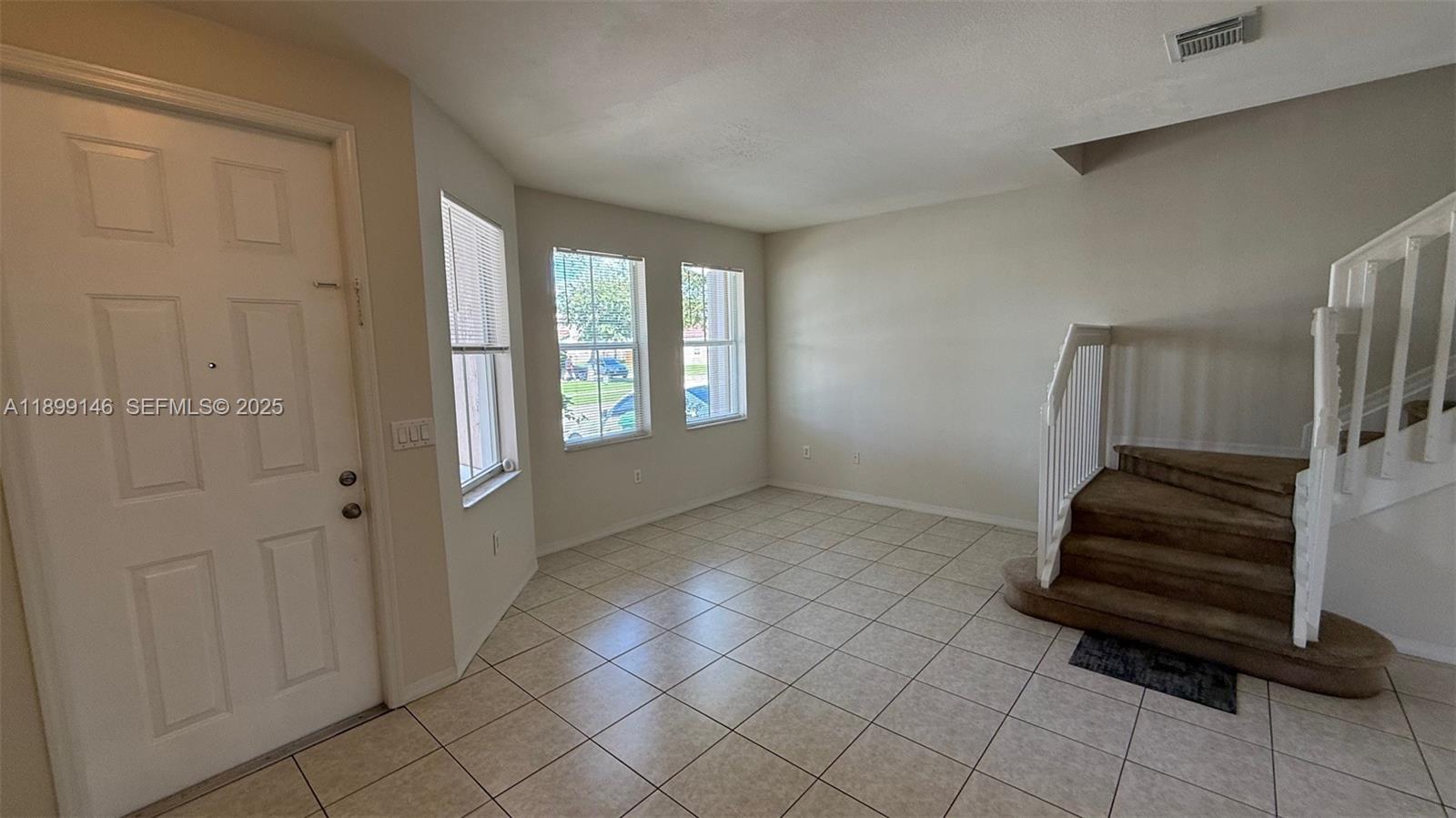 13810 Southwest 276th Street, Unit 13810 Homestead, FL 33032 - Photo 8 of 38 a view of a livingroom with stairs and a window