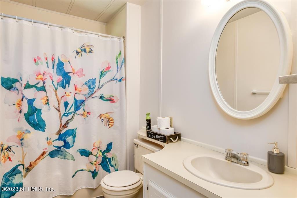 2221 Twin Fox Trail St. Augustine, FL 32086 - Photo 22 of 36 a bathroom with a sink mirror and toilet