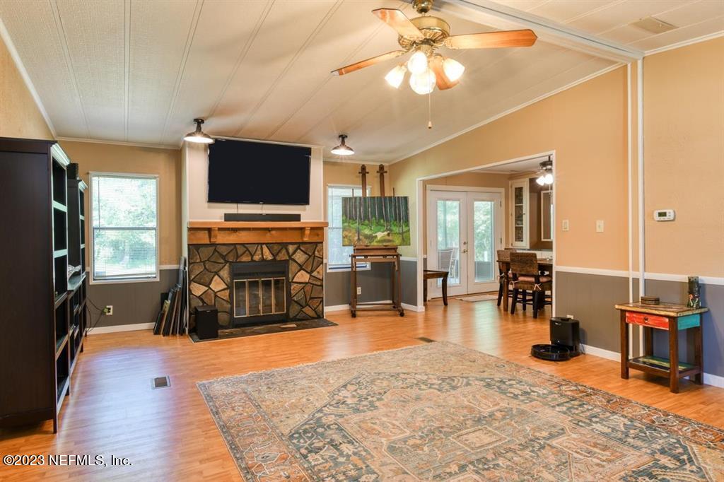 2221 Twin Fox Trail St. Augustine, FL 32086 - Photo 8 of 36 a living room with furniture a flat screen tv and kitchen view