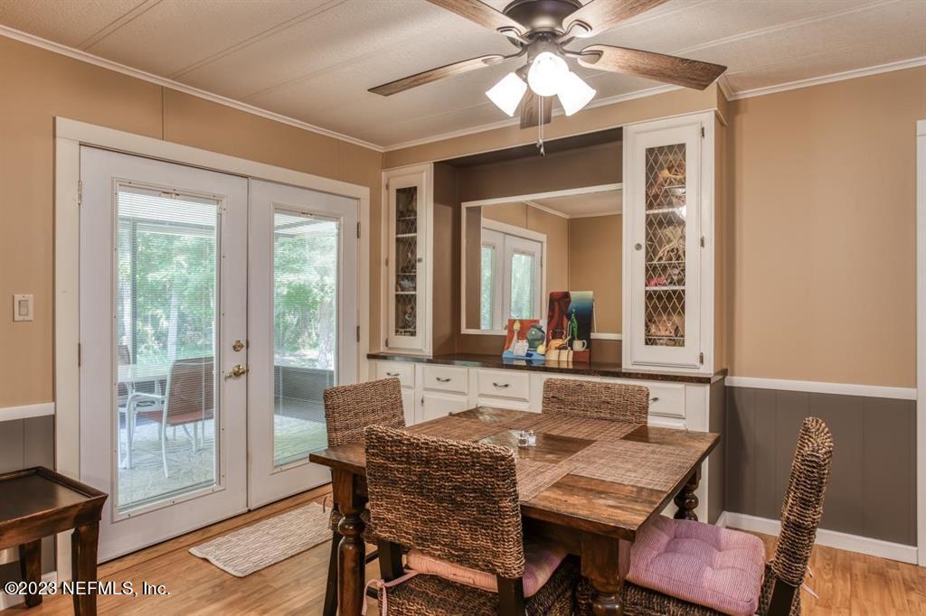 2221 Twin Fox Trail St. Augustine, FL 32086 - Photo 10 of 36 a dining room with wooden floor a chandelier fan a wooden table and chairs