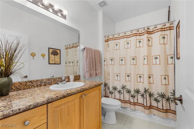 a bathroom with a granite countertop sink a toilet and shower