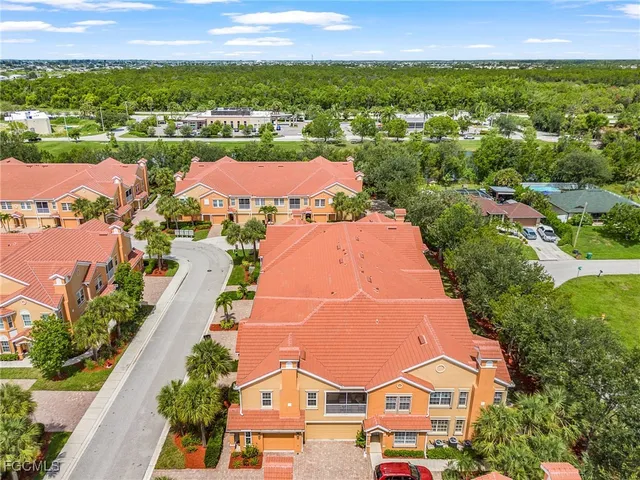 an aerial view of residential houses with outdoor space and trees
