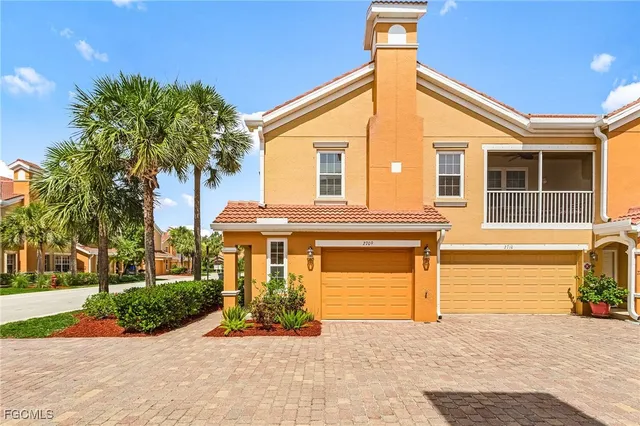 a front view of a house with a yard and potted plants