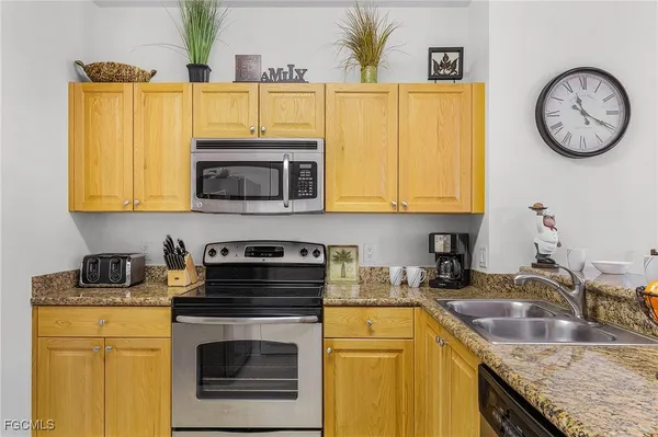 a kitchen with stainless steel appliances granite countertop a sink a stove and a microwave