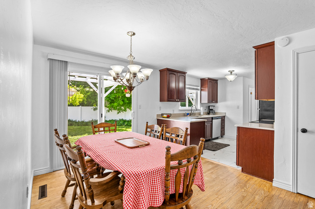 480 North 150 E Street Springville, UT 84663 - Photo 11 of 36 Dining area featuring wood-finish flooring, a chandelier, and sliding glass doors opening to the backyard
